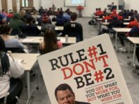 photo of Daniel Milstein's book "Rule number one don't be number two" being held up in front of classroom with Dan on a screen via zoom call.