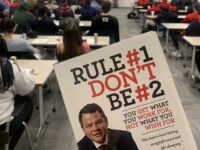 photo of Daniel Milstein's book "Rule number one don't be number two" being held up in front of classroom with Dan on a screen via zoom call.