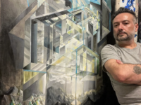 Artist stands next to one of his paintings